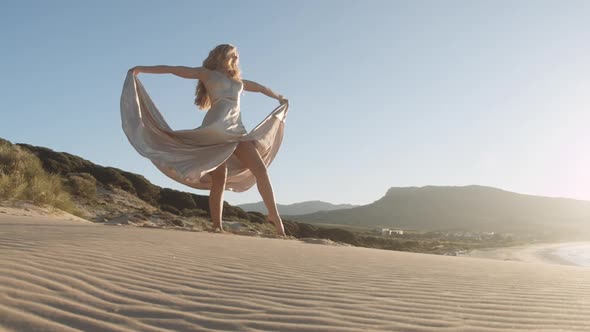 Dancing Young Woman In Gold On Beach