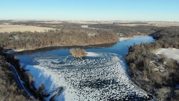 Aerial video flying high above a frozen Pine Lake State Park in Eldora Iowa