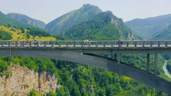 Aerial View of the People on Djurdjevica Tara Bridge Viewing the River Flowing Downstream From the