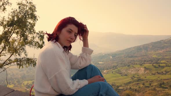 Girl looking out in the mountains at sunset