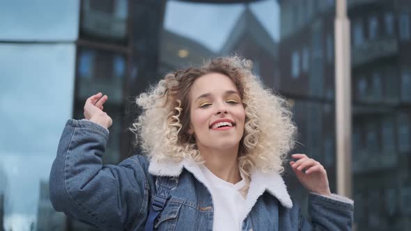 Beautiful Cheerful Girl Funny Shakes Curls and Smiles at the Camera.