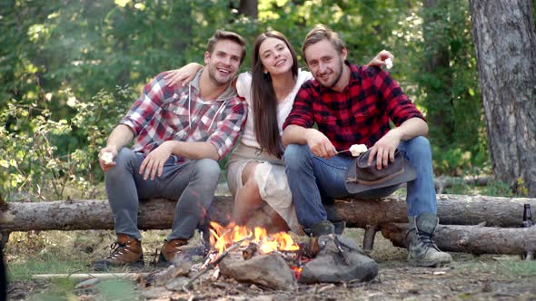 Friends Relaxing Near Campfire After Day Hiking or Gathering Mushrooms. Tourism Concept. Best