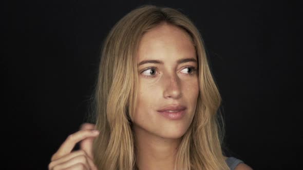 Woman looking down in thought and then smiling and snapping fingers