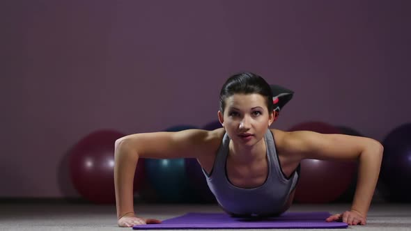 Successful Goal-Oriented Young Woman Doing Knee Push-Ups With Smile on Face