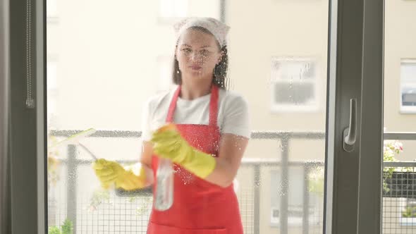 Cleaning Service Worker or Housewife Washes the Windows Using Detergent and Scraper for Cleaning