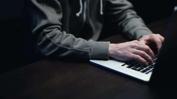 Pedestal Shot of Hacker Man Hacking Web Site or Engaging Hacking Into Security Systems at Dark Room