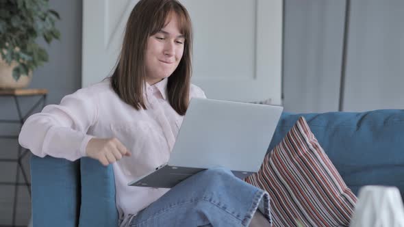 Casually Sitting Young Girl Celebrating Success on Laptop