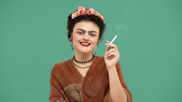 Portrait of Gorgeous Woman with Thick Eyebrows Like Frida Kahlo Smiling and Smoking Cigarette