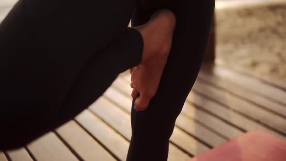 Slender Woman in Black Sportswear Practicing Yoga on Mat in Front the Sea in the Morning Performing