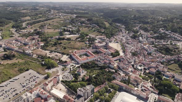 Drone capturing Alcobaça cityscape with the monastery at center, aerial circular pan shot.