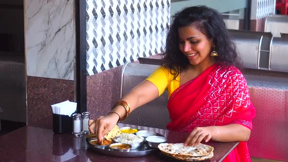 Beautiful Woman Eating Dosa Chutney Naan and Indian Tali in a Restaurant