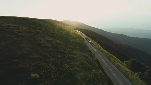 Aerial View of Biker Going Down a Mountain Passage Road at Sunset