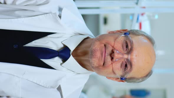 Vertical Video Portrait of Senior Experienced Scientist Man Smiling at Camera