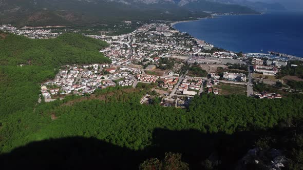 Caucasian Man is Standing on the Edge of Precipice Enjoying the View of Kemer City and Shoreline