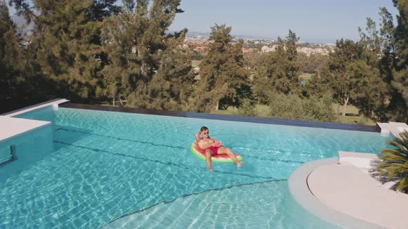 Drone On Man On Inflatable In Swimming Pool