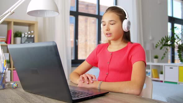 Girl in Headphones with Laptop Computer at Home