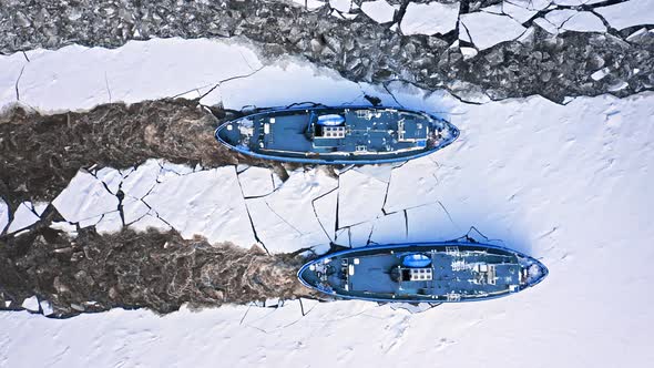 Two icebreakers on frozen river in winter, Poland.