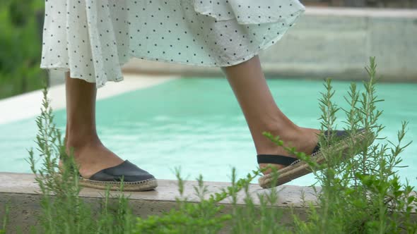 Closeup of woman walking in dress, feet and sandals traveling at a luxury resort in Italy, Europe.