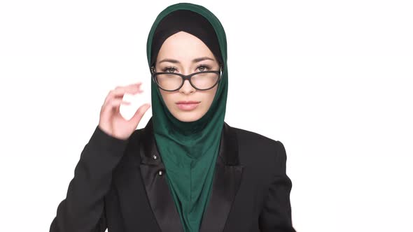 Portrait of Decisive Arabic Woman in Headscarf and Eyeglasses Posing on Camera with Confident Look