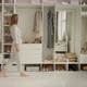 Girl Approaches a Wardrobe with Clothes Tries on a Striped Dress - VideoHive Item for Sale