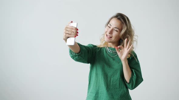 Portrait of Playful Young Woman Taking Selfie Using Smartphone Camera Posing Smiling
