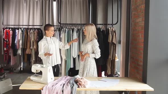 Modern Clothes Designer and Potential Client in Workplace Discuss Design of Future Dress