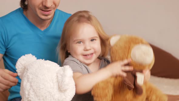 Dad Combs His Daughter's Hair Little Baby Girl on Bed in Bedroom