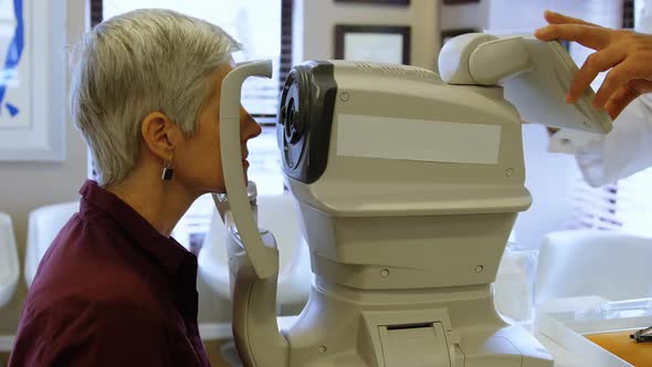 Optometrist examining patient eyes with autorefractors 4k