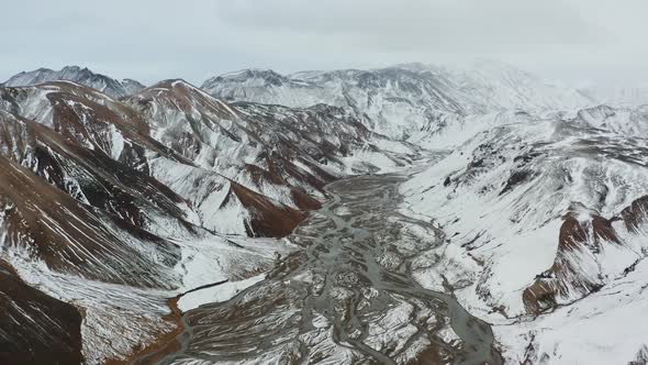 Drone Over Snow Covered Mountains Landscape With River
