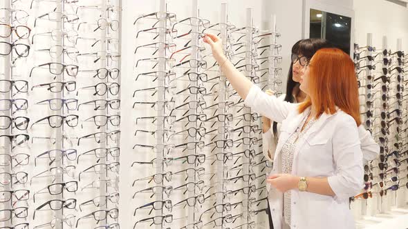 Pleasant Doctor Giving Customer Glasses To Try Them on