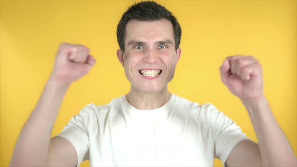 Slow Motion of Man Celebrating Success, Yellow Background