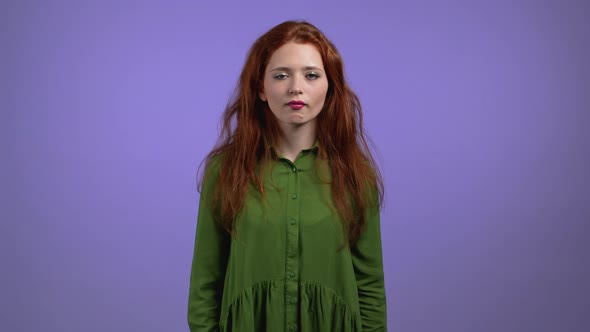 Irritated Woman in Green Sighs Rolling Eyes on Violet Background