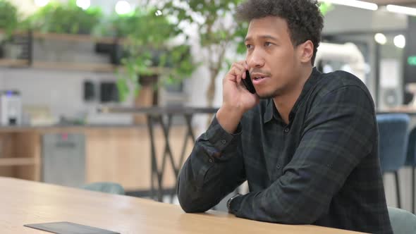 African American Man Talking on Smartphone at Work