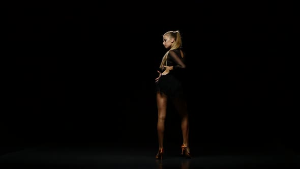 Professional Beautiful Dancer Cha-cha-cha in a Studio on a Dark Background