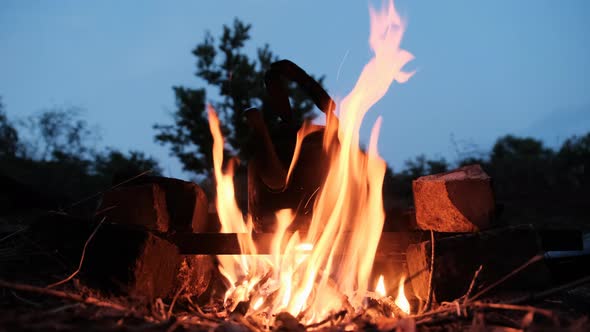 Old Tourist Kettle Standing on Campfire with Flames in Tourist Camp at Twilight