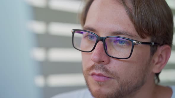 Male Eyes in Eyeglasses in Front of Laptop