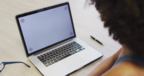 Video of biracial woman working with laptop with copy space on screen