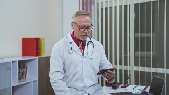 Doctor speaks with patient. Doctor with stethoscope in surgery office talking to patient online