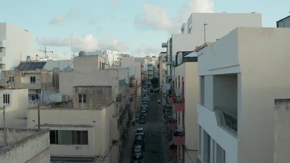 Empty Mediterranean City Street in Malta, Aerial Forward Dolly on Beautiful Blue Sky Day