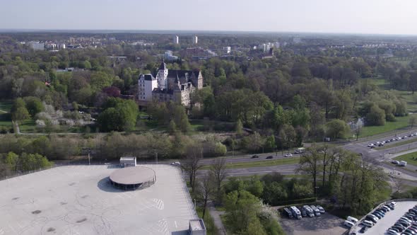 Fly in to Wolfsburg Castle over highway with cars, Germany