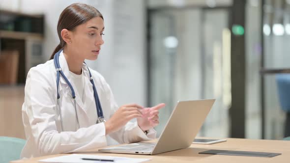 Female Doctor Thinking and Working on Laptop in Office