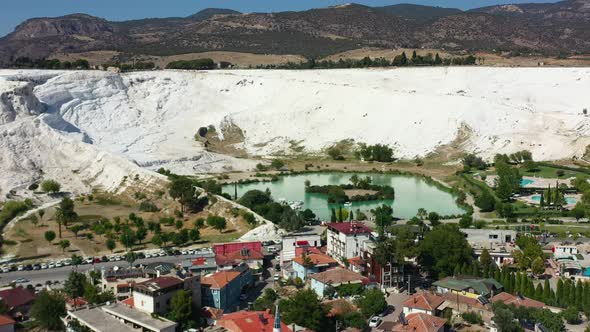 stunning aerial view of a blue lake surrounded by white mineral rich mountain terraces filled with t