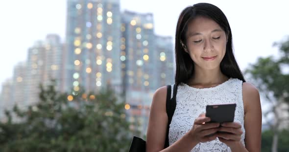 Woman use of cellphone in city at night  