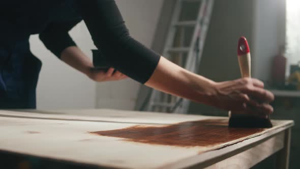 Woman Builder Varnishing Wooden Table Closeup