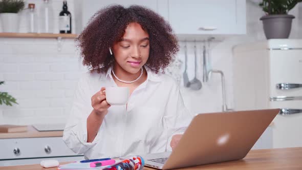 Young African American Woman Freelancer Having Breakfast Sits Front Laptop