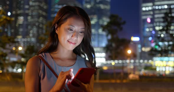 Woman use of mobile phone in the city at night