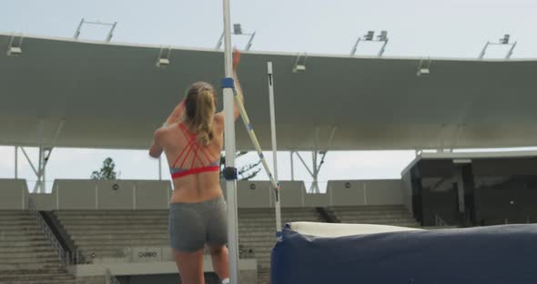 Side view of caucasian athlete doing high jump