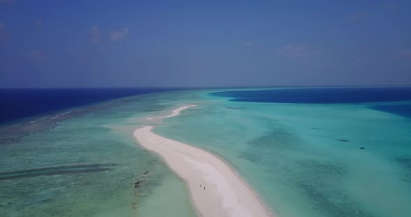 Daytime overhead island view of a sunshine white sandy paradise beach and aqua blue water background