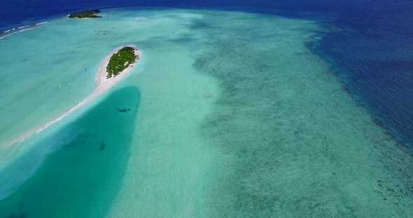 Natural above tourism shot of a sandy white paradise beach and blue sea background in 4K