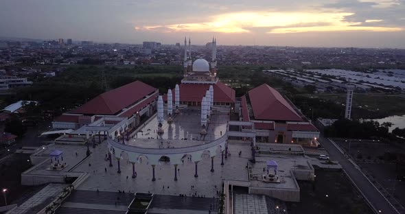 Orbit drone shot of the great Mosque of Central Java (MAJT) in suset time. Th sun is orange and the